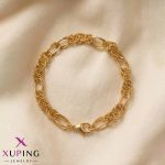 دستبند زنجیری طلایی رنگ برند ژوپینگ با طراحی ترکیبی از حلقه‌های بیضی ساده و حلقه‌های بافت‌دار قرار گرفته روی زمینه پارچه‌ای روشن