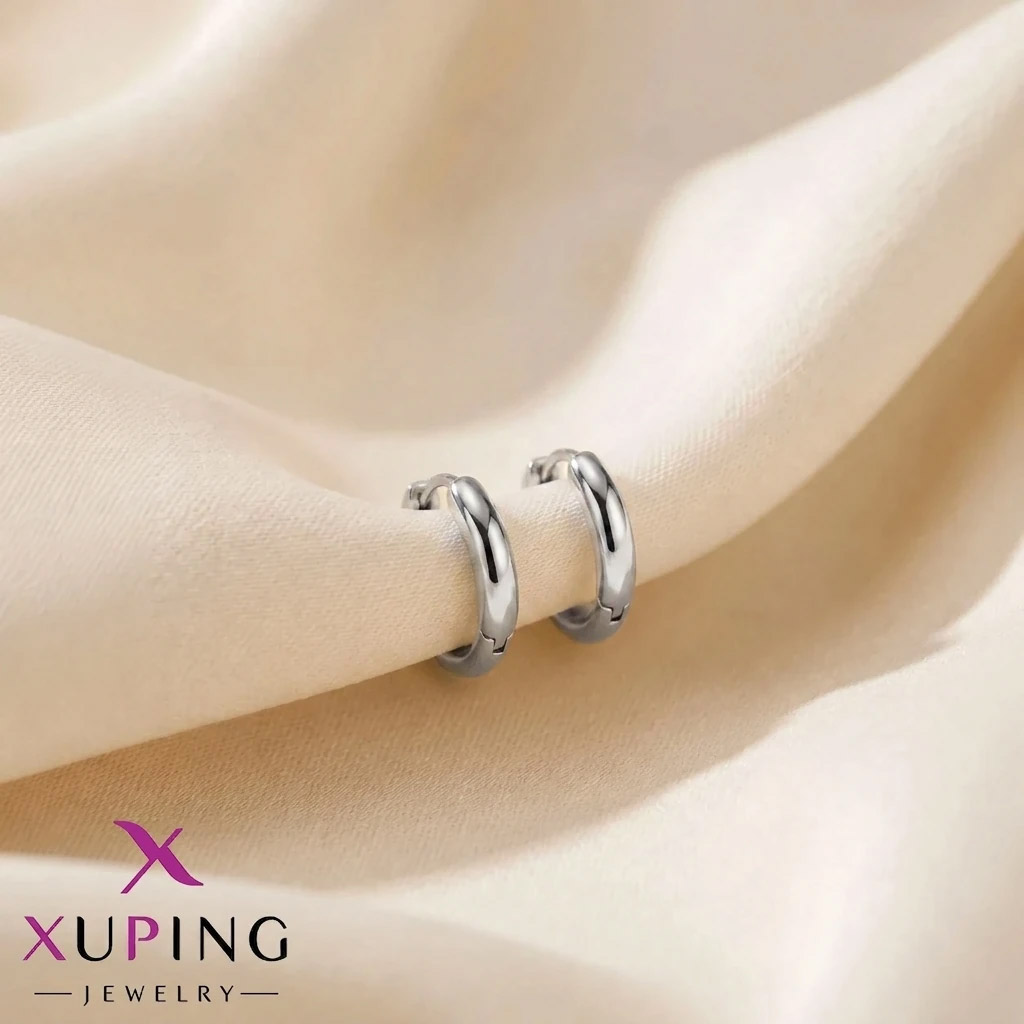 silver-color-Hoop-Earrings-Small-Classic یک جفت گوشواره حلقهای کوچک یک سانتیمتری، ساده و کلاسیک نقرهای رنگ برند ژوپینگ قرار گرفته روی پارچه حریر روشن